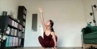 Học viên ngồi xổm, một tay vươn lên, mắt nhìn theo tay.
