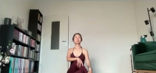 Học viên ngồi trên thảm trong phần vặn xoắn của buổi học yoga online.