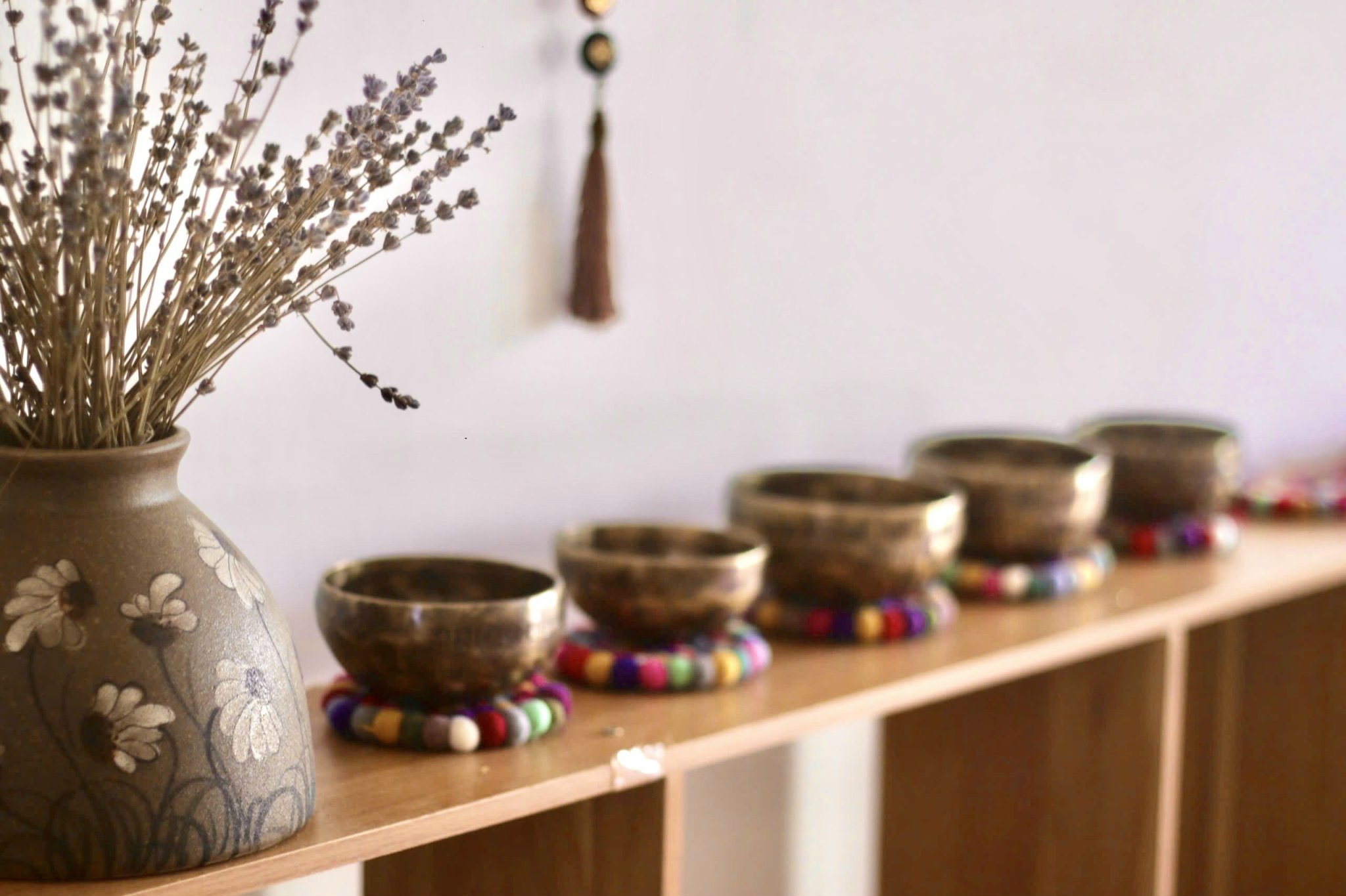 Chuông xoay Tây Tạng đặt cạnh bình hoa oải hương tạo không gian thiền thư giãn