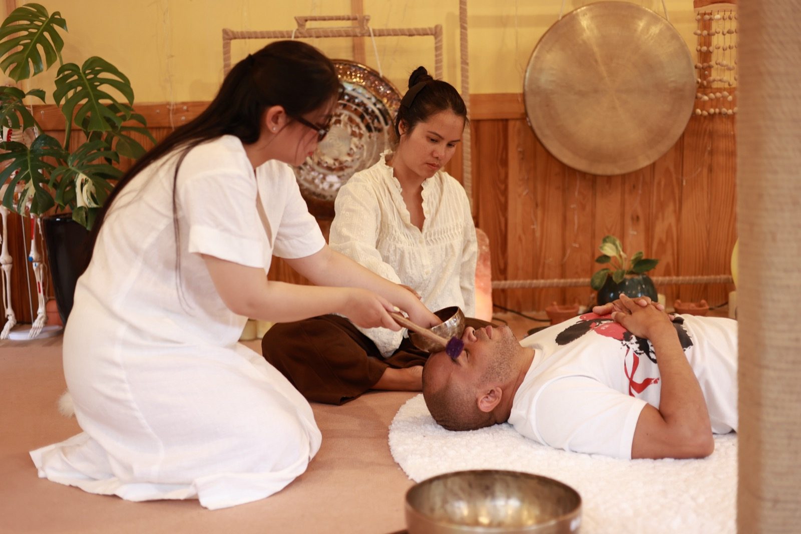 Hai người thực hành phục hồi chuông xoay cho người nhận — kỹ thuật đúng không chỉ là gõ, tại Giang Metta Đà Lạt