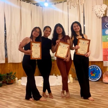 Graduates of the 200-hour yoga teacher training holding their certificates