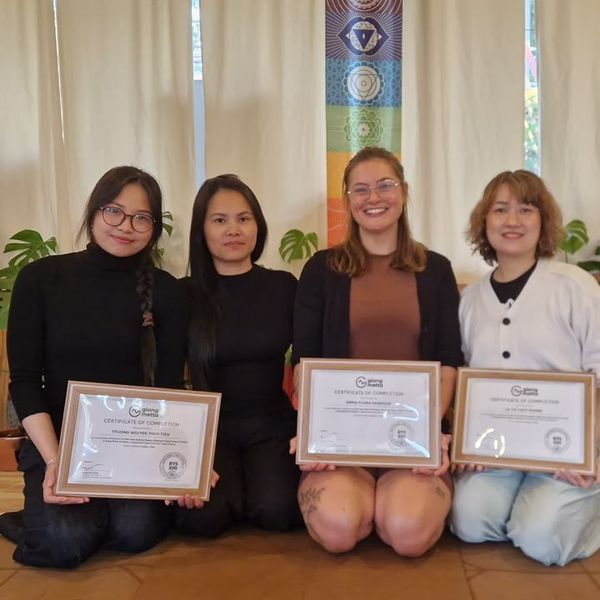 Four 200-hour yoga teacher training students with their certificates at the Da Lat studio