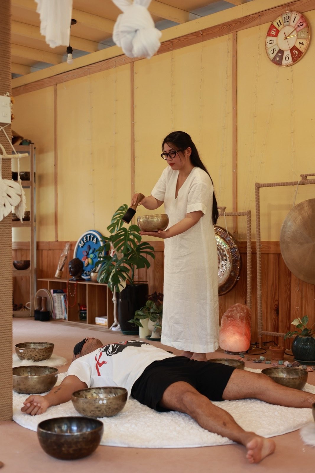 Buổi phục hồi chuông xoay 1:1 — chuông đồng đặt trên cơ thể người nhận tại studio Giang Metta Đà Lạt