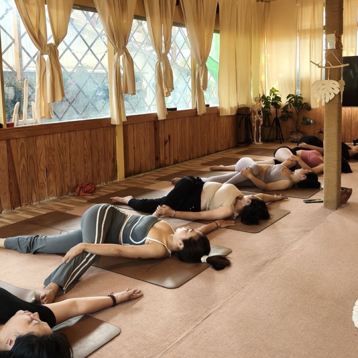 Lớp yoga tại Metta Đà Lạt — học viên thực hành Savasana trong không gian ấm cúng